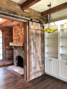 Reclaimed wood sliding doors, mantle, and beams by High Mountain Millwork Company - Franklin, NC